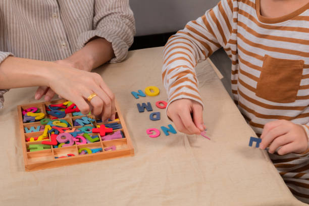 child and parent learning letters with wooden letters